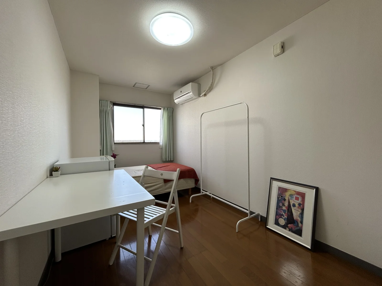机とハンガーラックのあるお部屋