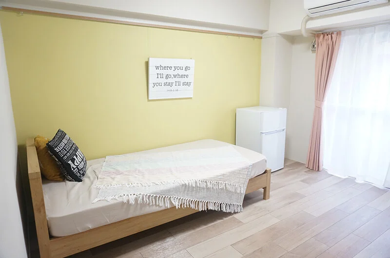 壁が黄色のお部屋。冷蔵庫があります